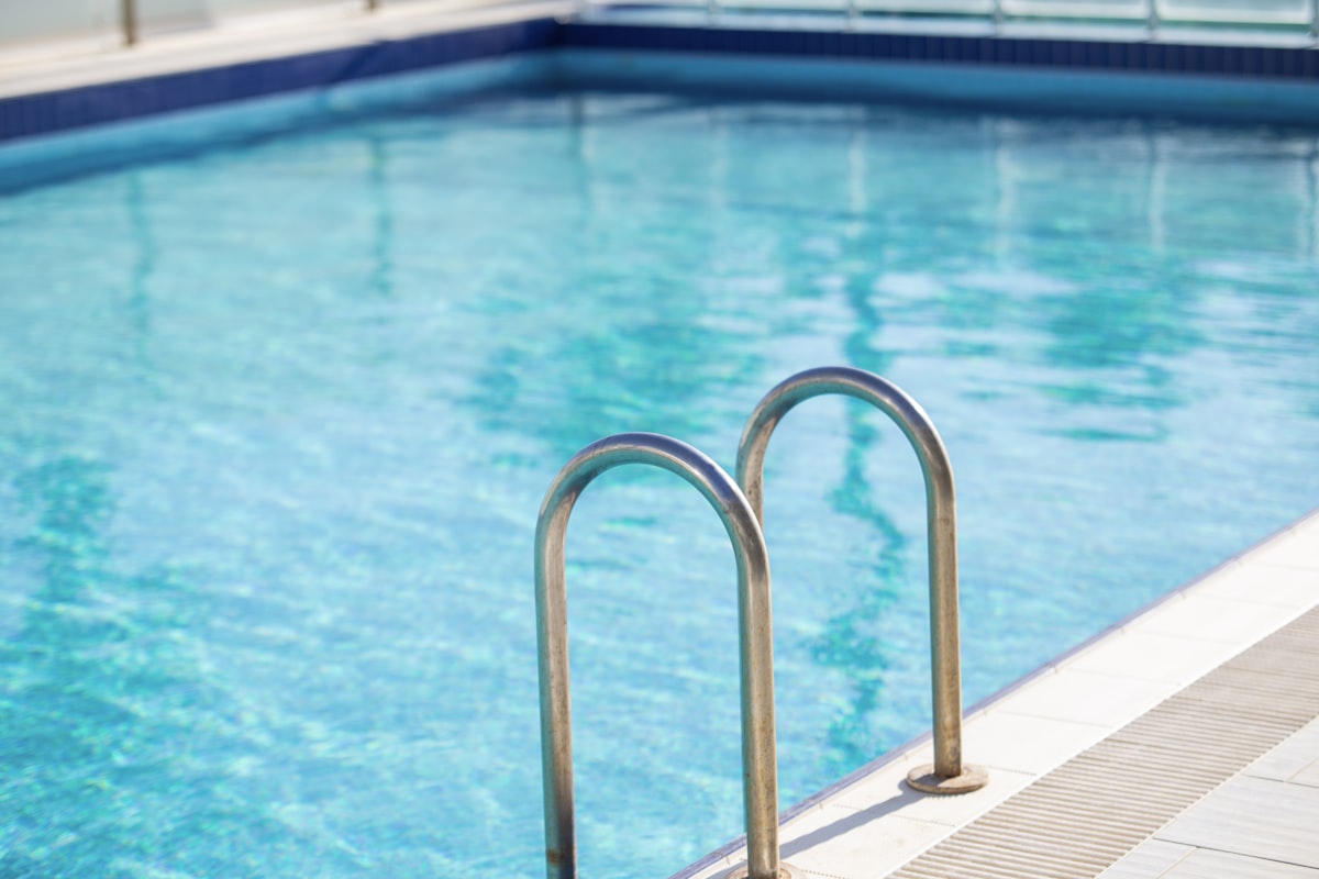 Stainless steel safety railing beside a swimming pool