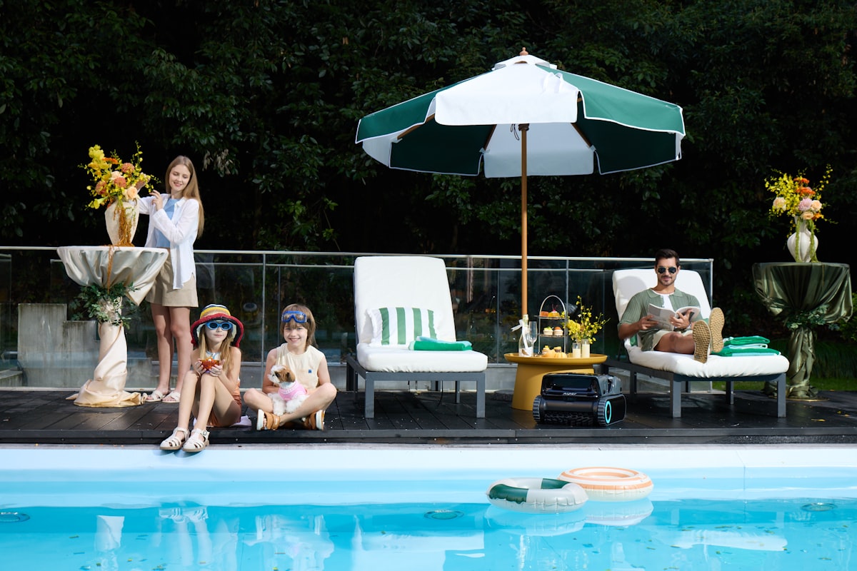 Family relaxing by the pool with their dog nearby