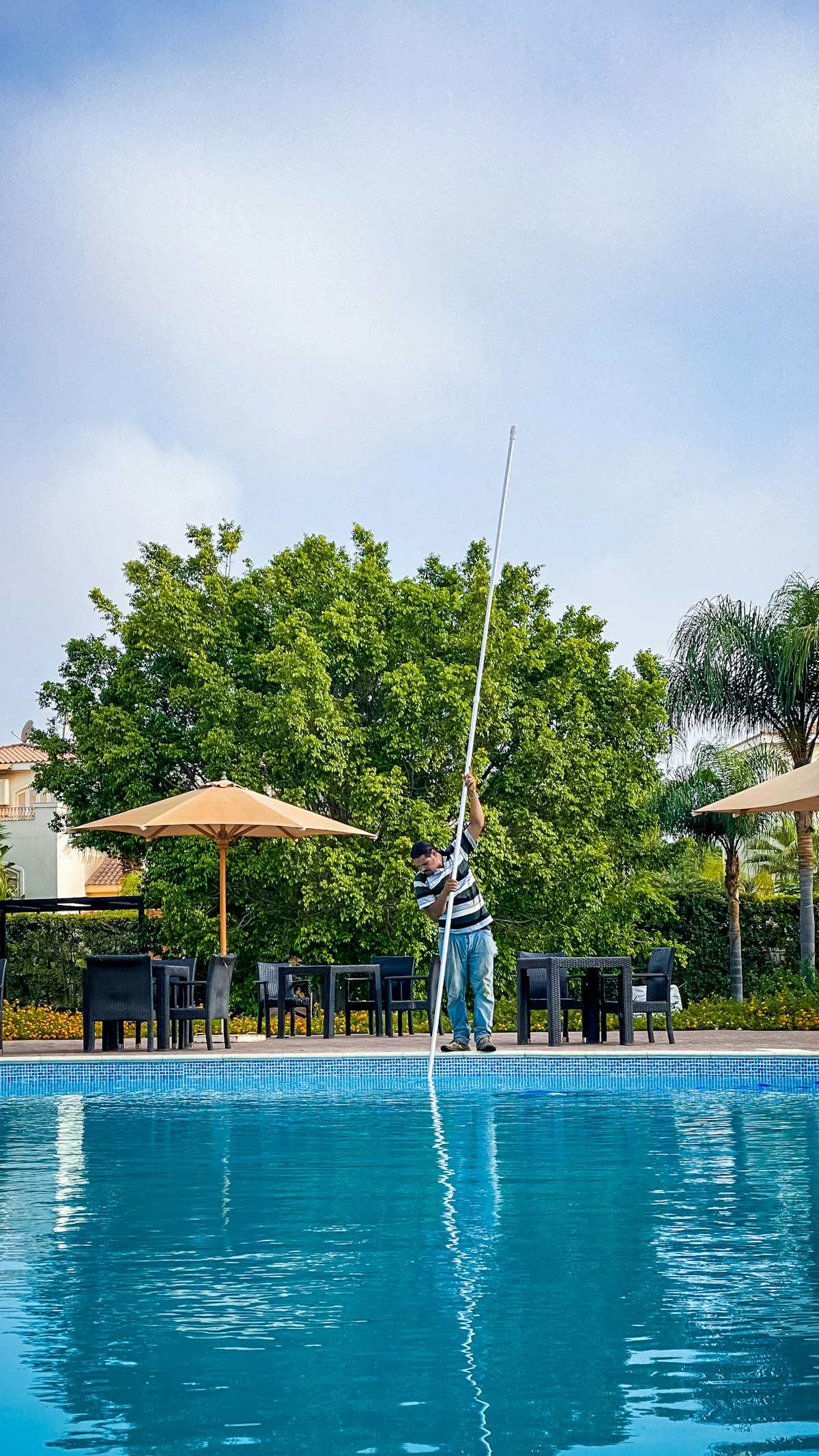 Pool service professional standing beside a swimming pool